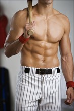 Portrait of baseball player with bare chest holding bat. Date : 2008