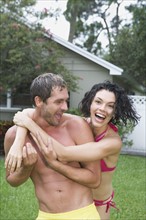 Couple in bathing suits hugging in backyard. Date : 2008