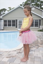 Girl standing at poolside looking sad. Date: 2008
