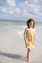 Girl walking through ocean surf. Date: 2008