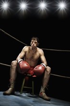 Boxer sitting on stool in corner of boxing ring. Date: 2008