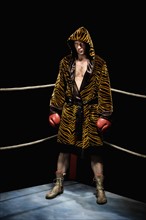 Boxer in robe posing in boxing ring. Date : 2008
