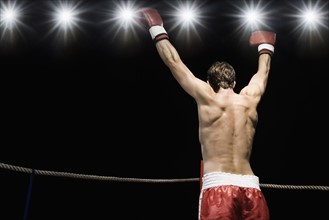 Boxer standing in boxing ring with gloves raised. Date: 2008