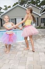 Sisters playing by swimming pool. Date: 2008