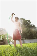 Boy spraying himself with hose in backyard. Date : 2008