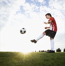 Boy in uniform kicking soccer ball. Date : 2008