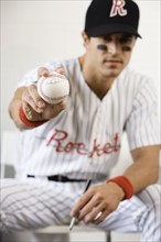Portrait of baseball player holding autographed baseball. Date : 2008