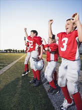 Football players cheering on sideline. Date: 2008