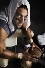 Football player with towel on head holding football. Date: 2008