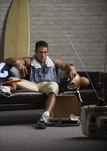 Football player watching game on sofa. Date : 2008