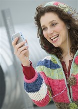 Woman looking at mp3 player and smiling.