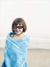 Portrait of girl in sunglasses wrapped in a towel on beach. Date: 2008