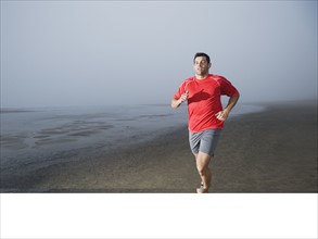 Man jogging on foggy beach. Date : 2008