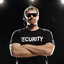 Security guard with headset posing with arms crossed. Date : 2008