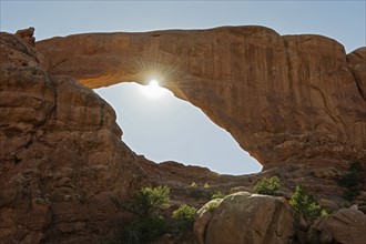 Sun shining behind South Window Arch in Arches National Park, Utah.