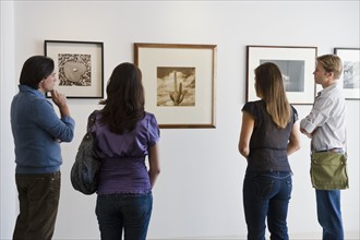 People looking at pictures in art gallery.