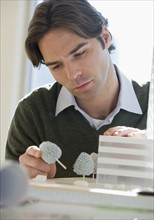 Close up of architect working on building model.