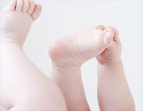 Close up of baby grabbing feet. Date: 2008