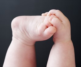 Close up of baby grabbing foot. Date : 2008