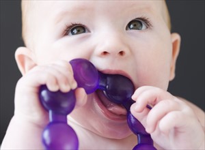 Close up of baby gnawing on teething ring. Date: 2008