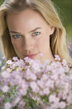 Woman posing behind flowers.