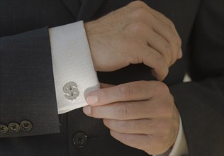 Close up of businessman wearing dollar sign cuff link.