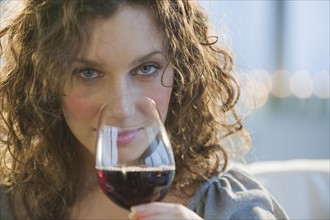 Close up of woman smelling red wine.