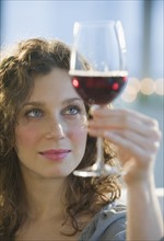 Woman examining coloring of red wine.