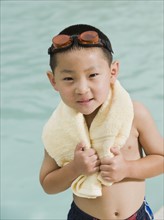 Boy wrapped in towel posing in front of swimming pool. Date : 2008