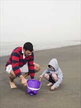 Father and son playing on beach. Date : 2008