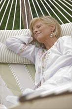 Woman napping on hammock.