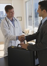 Doctor and businessman shaking hands.