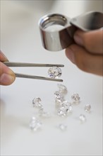 Gemologist inspecting diamonds using loupe.