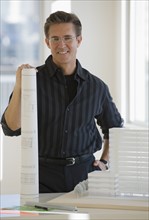 Portrait of architect with blueprint and building model.