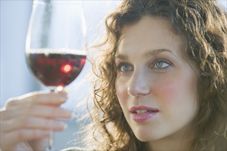 Close up of woman examining coloring of red wine.