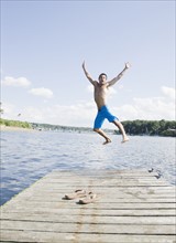 Portrait of man jumping off dock into lake. Date : 2008