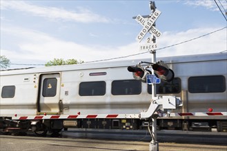 Commuter train moving through railroad crossing. Date : 2008