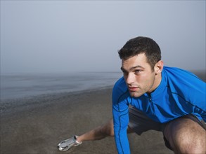 Man stretching on foggy beach. Date : 2008