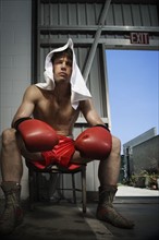 Portrait of boxer sitting on stool near doorway. Date: 2008