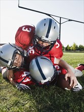 Football players piled on ball. Date: 2008