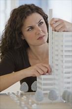 Close up of architect measuring building model.