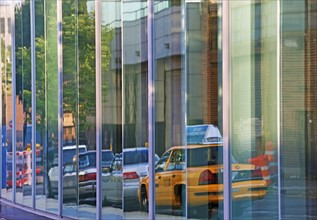 Reflection of taxi cab and cars on building. Date : 2008