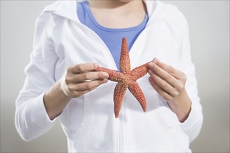 Portrait of girl holding starfish. Date : 2008