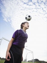Boy bouncing soccer ball on head. Date: 2008