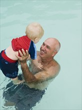 Grandfather and grandson in swimming pool. Date : 2008
