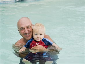Grandfather and grandson posing in swimming pool. Date: 2008