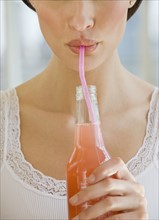 Close up of woman drinking soda from a straw.