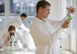 Scientist examining liquid in pharmaceutical laboratory.