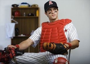 Baseball catcher sitting in locker room looking pensive. Date : 2008