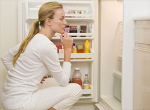 Woman looking inside refrigerator.